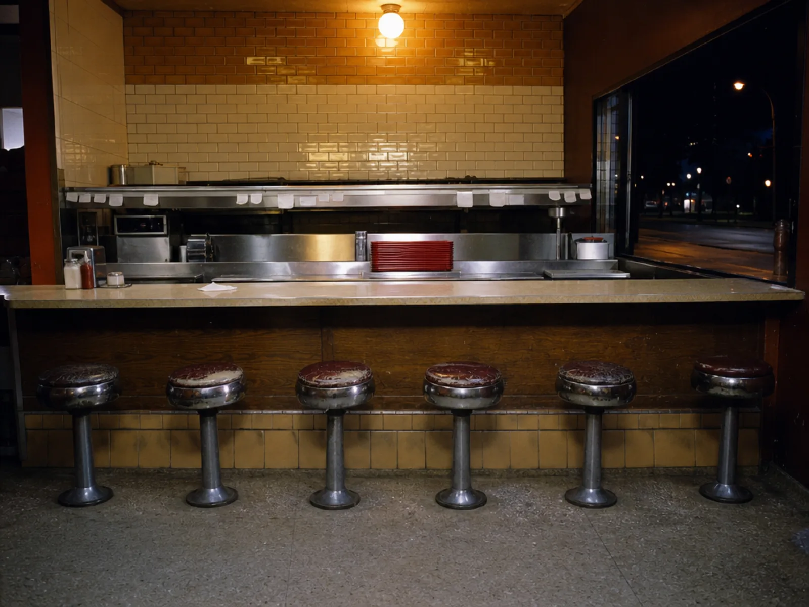 The counter and stools after service, the street dark outside