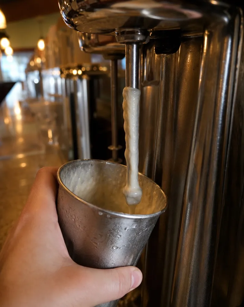 A glass being poured at the counter
